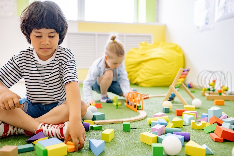 Illustration of a child with autism playing with toys, surrounded by different colored puzzle pieces, symbolizing the complexity and uniqueness of autism spectrum disorder.